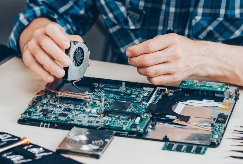 a man repairing a computer hard drive