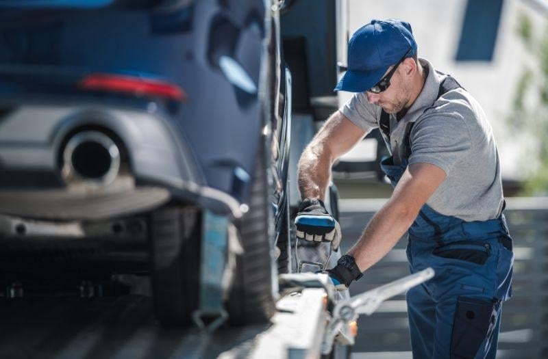 a tow truck technician stabalizing a vehicle